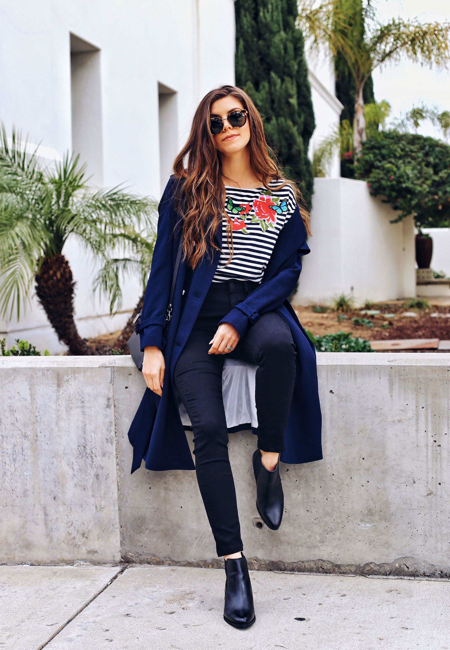 Fashion and lifestyle blogger Adelina Perrin of The Charming Olive wearing Marks & Spencer Coat, Striped Shirt, leather black boots and black jeans