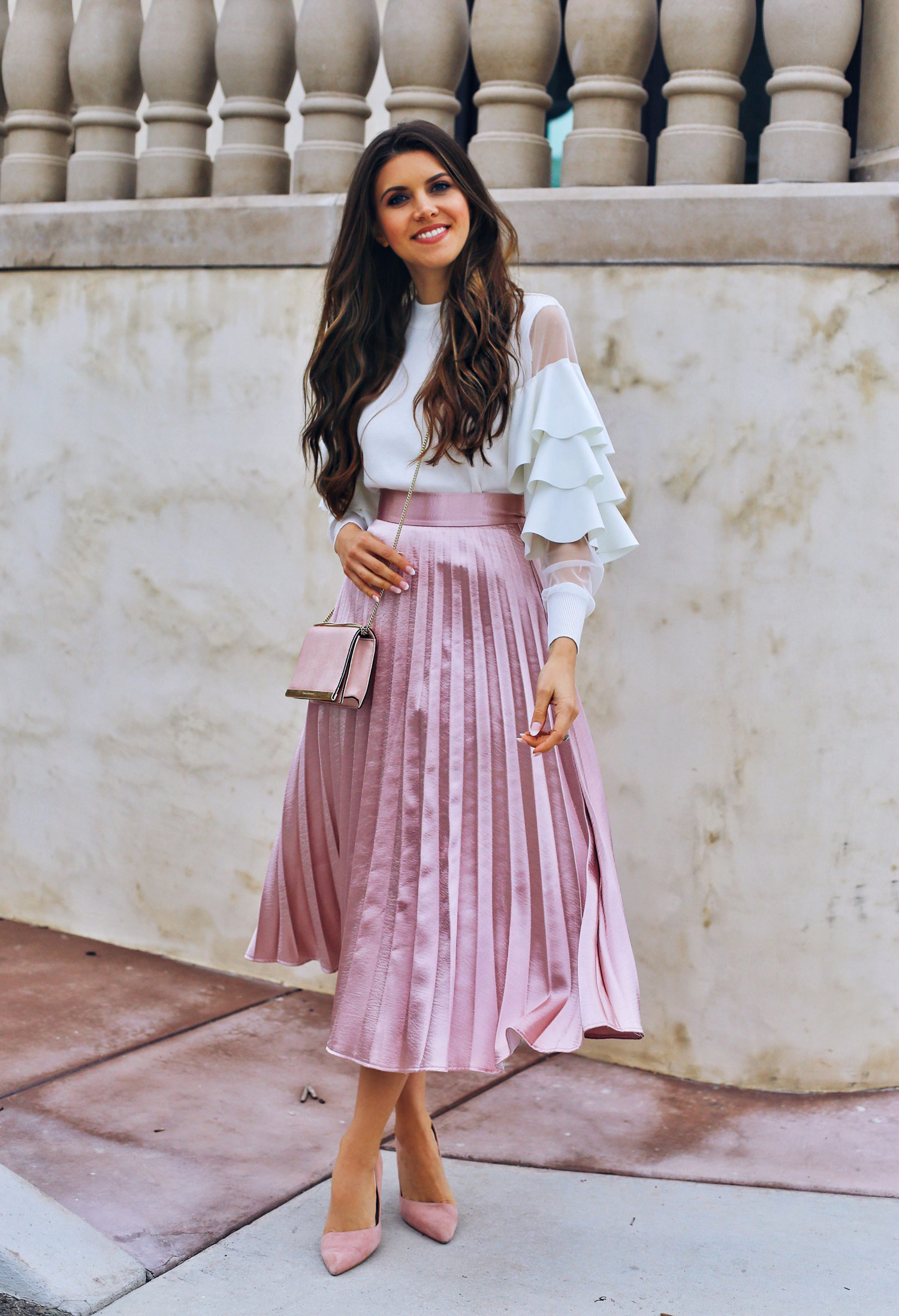 Fashion and lifestyle blogger Adelina Perrin of The Charming Olive wearing Chicwish tiered sleeve top and pink pleated skirt