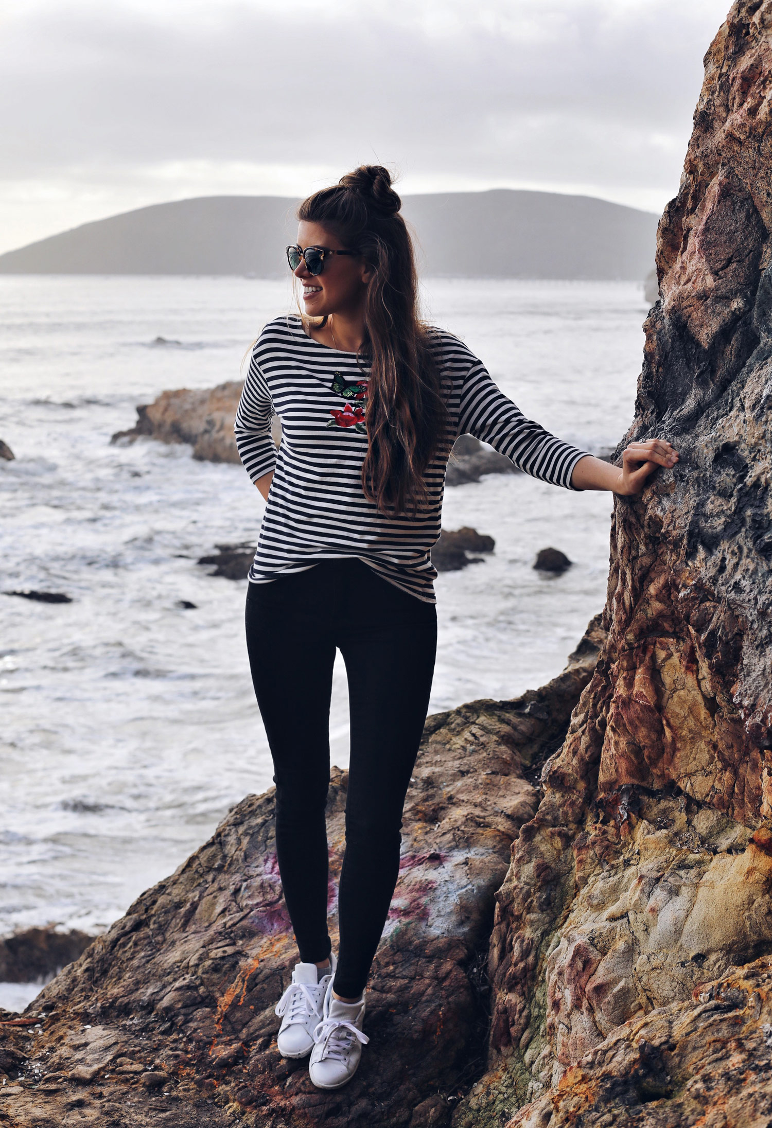 Fashion and lifestyle blogger Adelina Perrin of The Charming Olive wearing Marks & Spencer striped top, Mott & Bow Jeans, Adidas Sneakers and Tory Burch Sunglasses